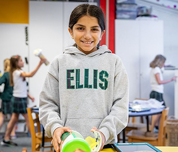A Middle School student in a classroom, wearing an Ellis sweatshirt.